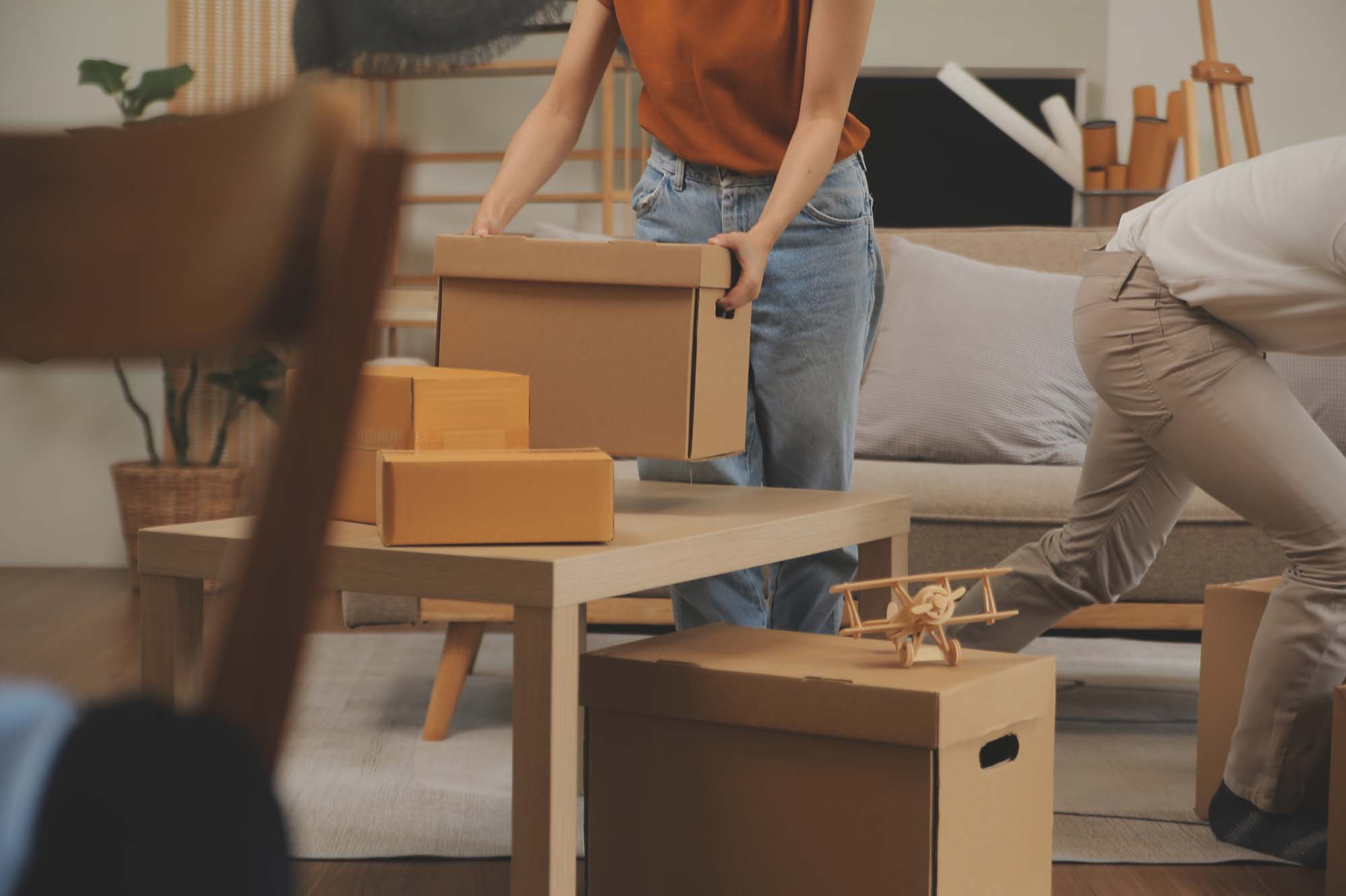 Beautiful young couple in love having fun unpacking things from cardboard boxes while moving in together in their new apartment